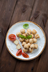 Mini provoletta cheese, dark wooden background, above view
