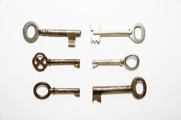 Six old keys to the safe on a white background