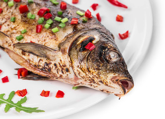 Grilled seabass with vegetables on plate.