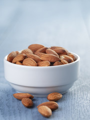 roasted almonds in white bowl on wooden table
