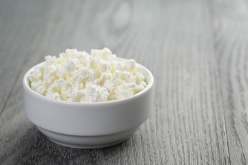 cottage cheese in white bowl on old table