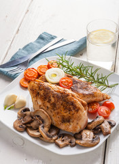 Baked chicken breast with mushrooms and carrots on plate