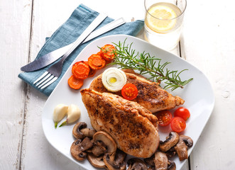 Baked chicken breast with mushrooms and carrots on plate