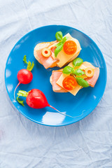 Small sandwiches with smoked ham, cheese and cherry tomato