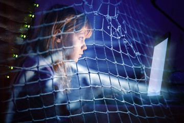 Little girl working on laptop at night in a fishing net