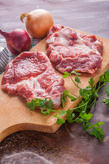 Raw pork chops on a wooden cutting board