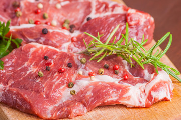 Raw pork chops on a wooden cutting board