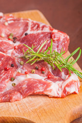 Raw pork chops on a wooden cutting board