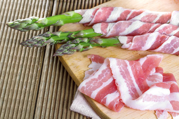 Bacon and asparagus on a wooden background