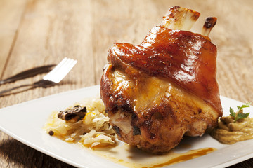 Roast pork knuckle served with boiled cabbage, bread, horseradis