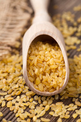 Natural super foods bulgur wheat grain in spoon close up