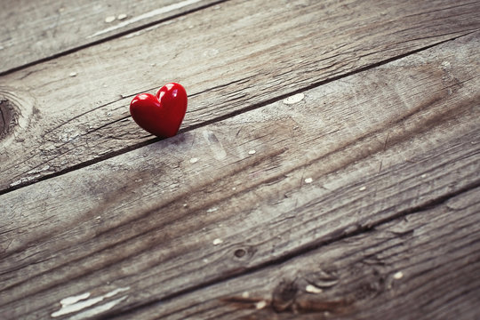 red heart on wooden desk