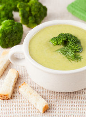 Broccoli soup dieting food with croutons on textile