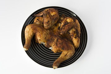 Roasted chicken on a striped black dish