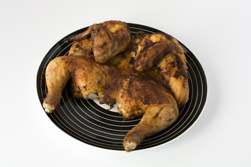 Roasted chicken on a striped black dish