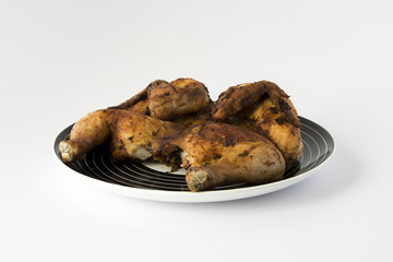 Roasted chicken on a striped black dish