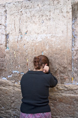Obraz na płótnie Canvas Woman prays at the Wailing Wall, Jerusalem Israel
