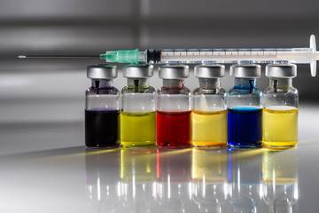 Ampoules in a row with syringe on top, mirroring