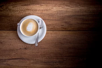 Fotobehang Cup of freshly brewed aromatic cappuccino standing on a wooden t © Gajus