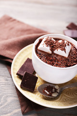 Hot chocolate with marshmallows in mug, on color wooden background