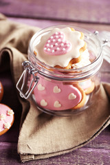 Heart shaped cookies for valentines day in glass jar on  wooden background