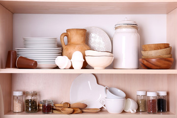 Kitchen utensils and tableware on wooden shelves
