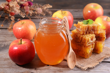 Delicious honey with apple on table close-up