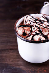 Mug of cocoa with marshmallows on wooden background