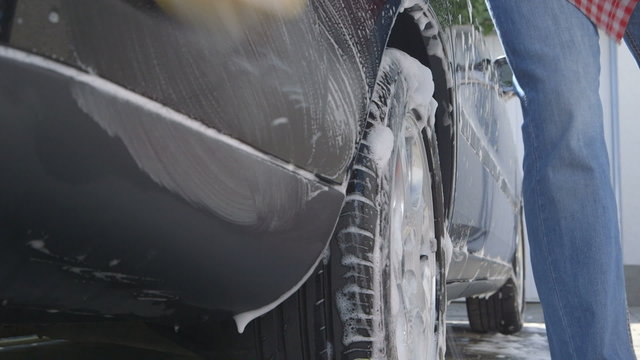 Washing a car by hand using a sponge - sliding camera