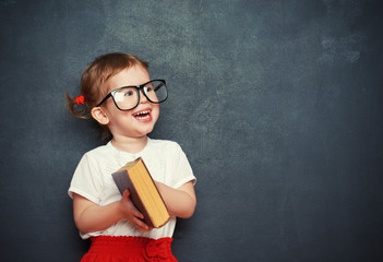 happy  girl schoolgirl with book from blackboard © JenkoAtaman