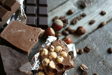 Set of chocolate with nuts on wooden table, closeup