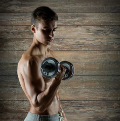 Fototapeta na wymiar young man with dumbbell flexing biceps