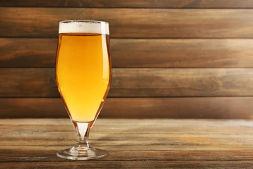 Glass of beer on wooden background