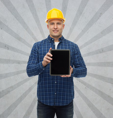 smiling male builder in helmet with tablet pc