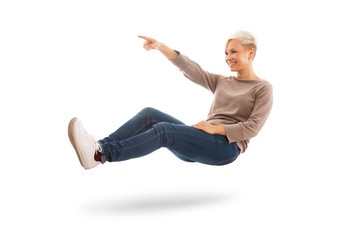 Casual dressed woman is floating while indicating a direction ov