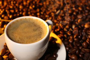 Cup of coffee with grains, closeup