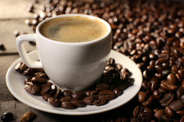 Cup of coffee with grains, closeup