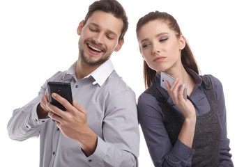 Attractive couple using their smartphones on white background
