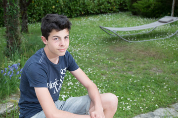 Teenager boy is posing outside in the garden
