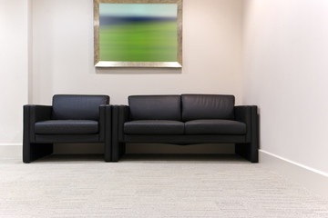 Black leather chairs in a modern office waiting room