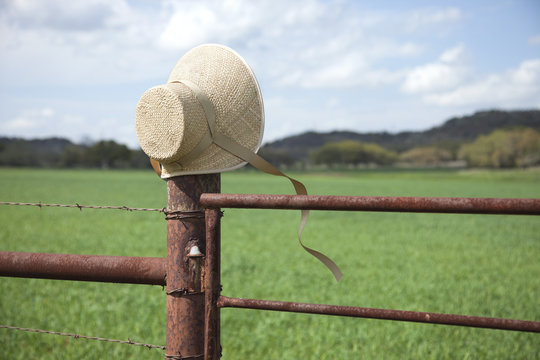 Old fashioned straw bonnet on fence post in Texas Hill Country