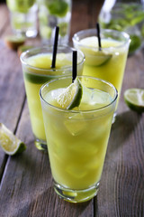 Glasses of cocktails on wooden table, closeup
