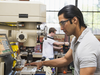 Workers using machinery in machine shop