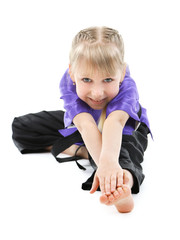 Little girl in kimono doing exercises isolated on white