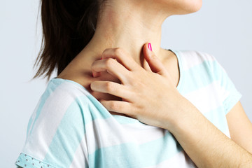 Woman has itch on gray background