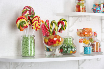 Colorful candies in jars on shelves close-up