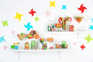 Colorful candies in jars on shelves close-up