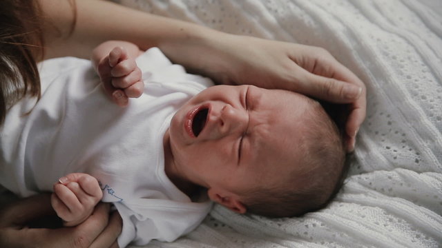 newborn baby crying. mother soothes