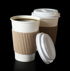 Paper cups of coffee on black background