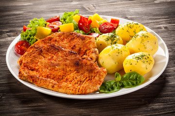 Fried pork chops, boiled potatoes and vegetable salad